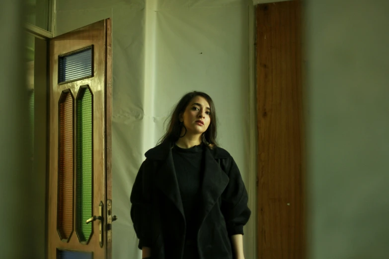 a woman in a black top standing by a door