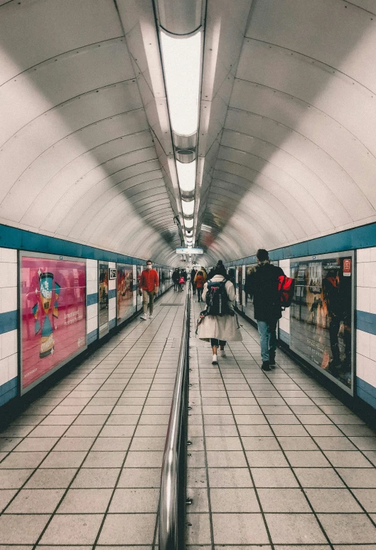 a person riding on the back of a train in a station