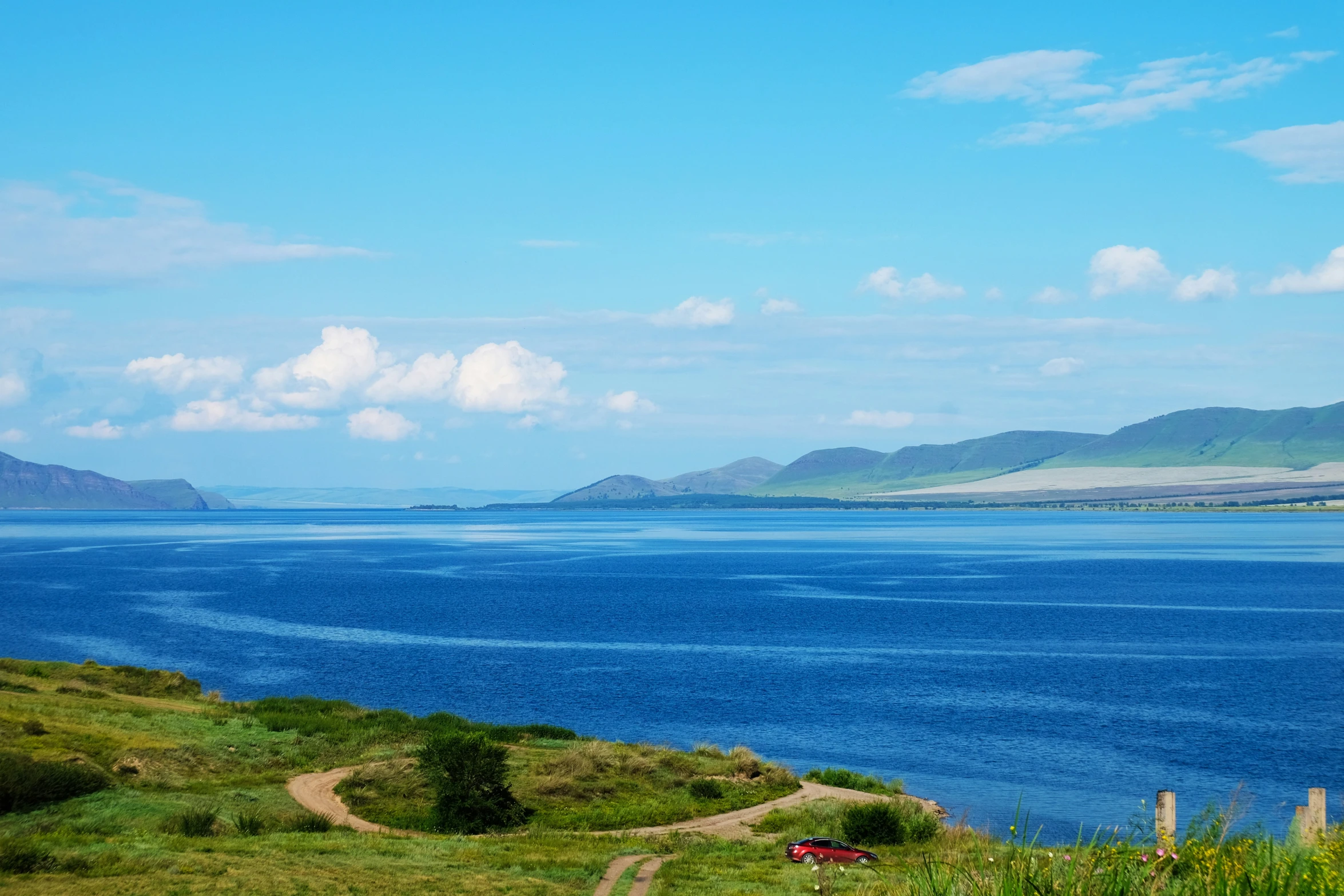 a large body of water near a grassy area