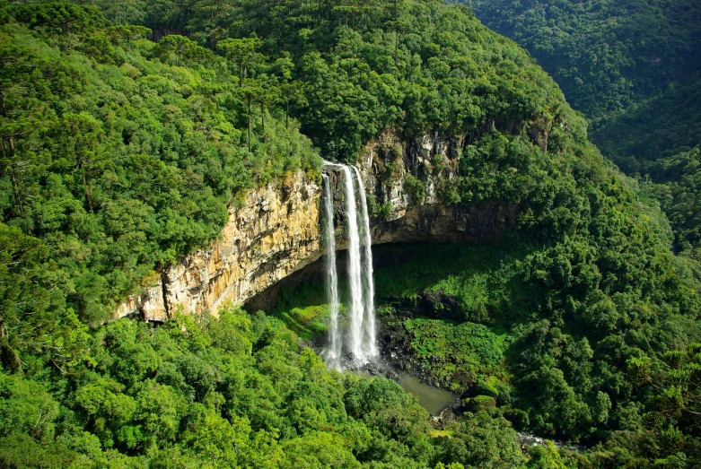 the waterfall at the top of the cliff has a river flowing underneath