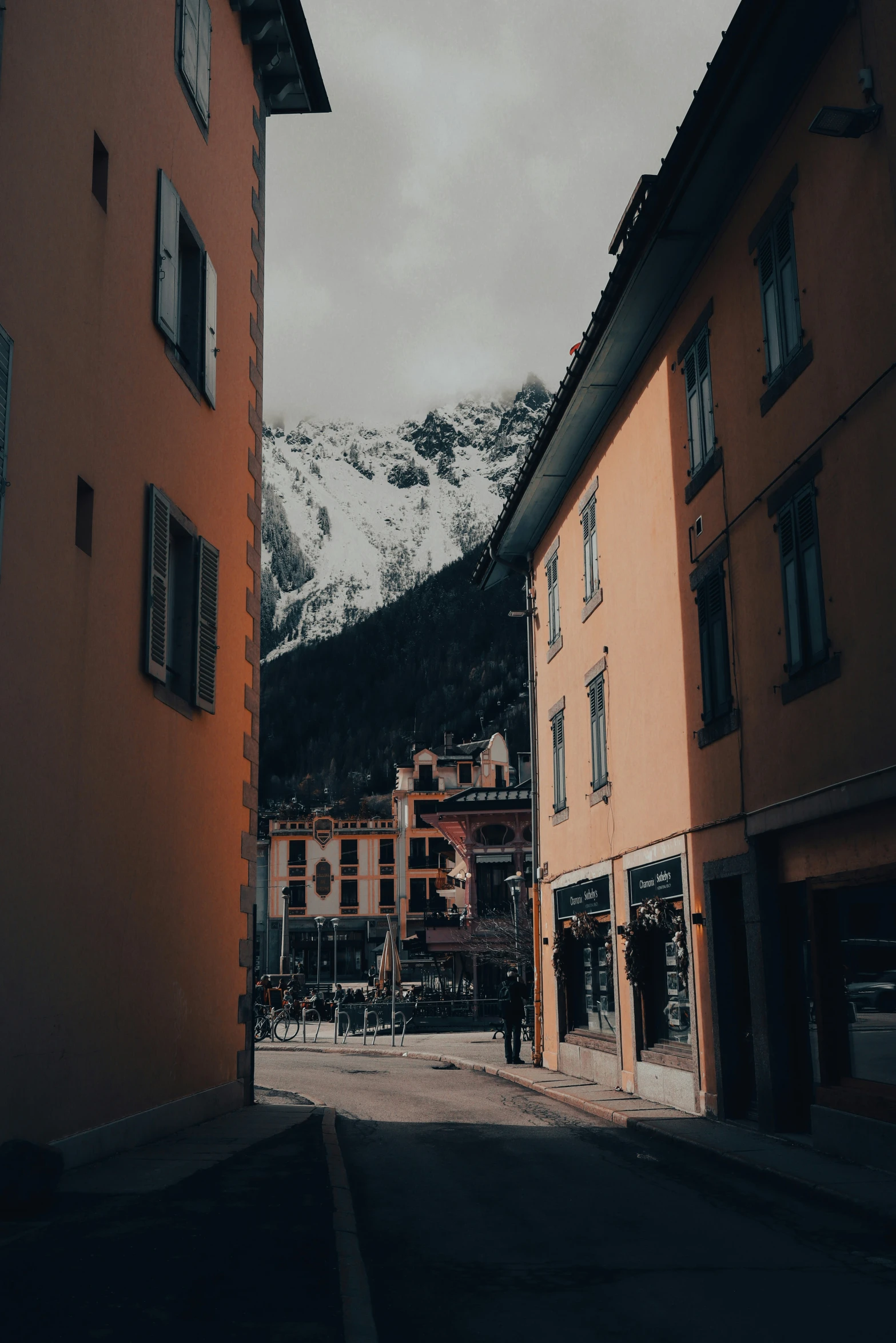 the view from the outside of a small town in front of snowy mountains