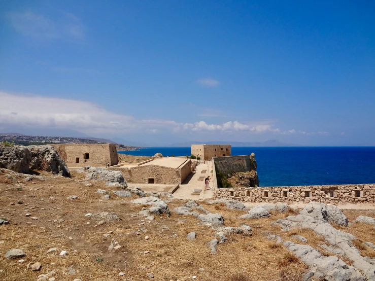 a large castle sits on a hillside overlooking the ocean