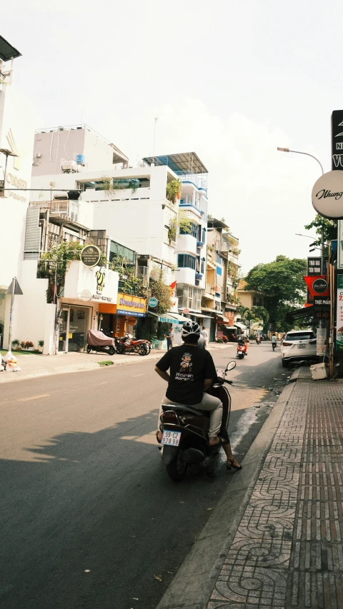 a man rides his motorcycle on a narrow street