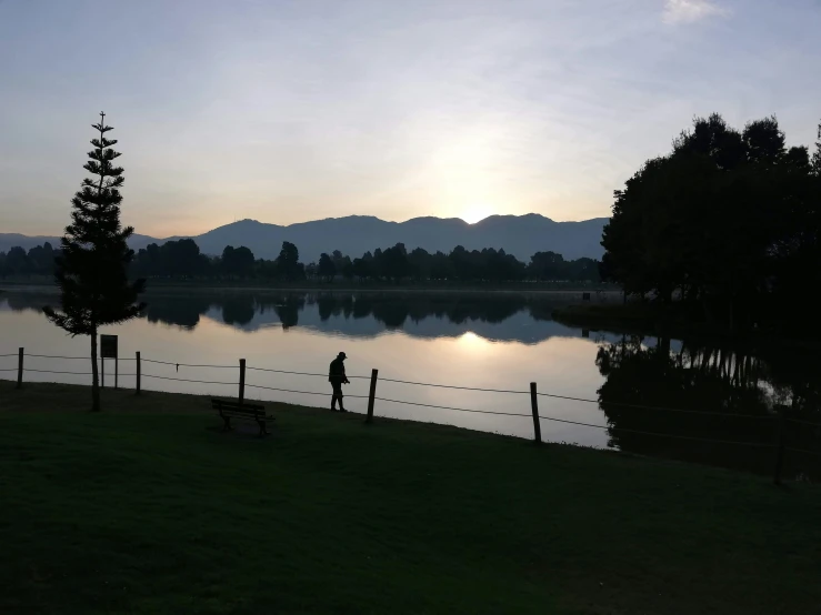 a couple of people standing in front of a lake