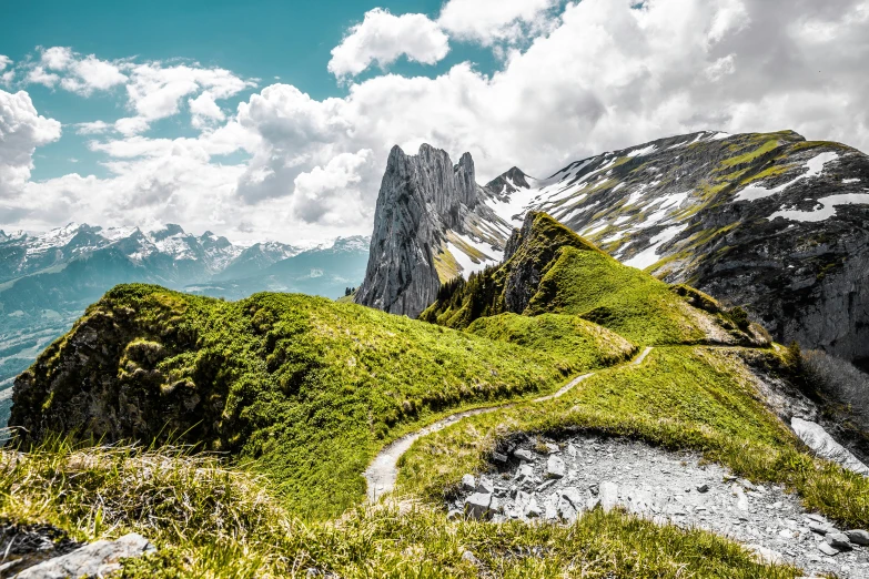 mountains covered with green grass under a partly cloudy sky