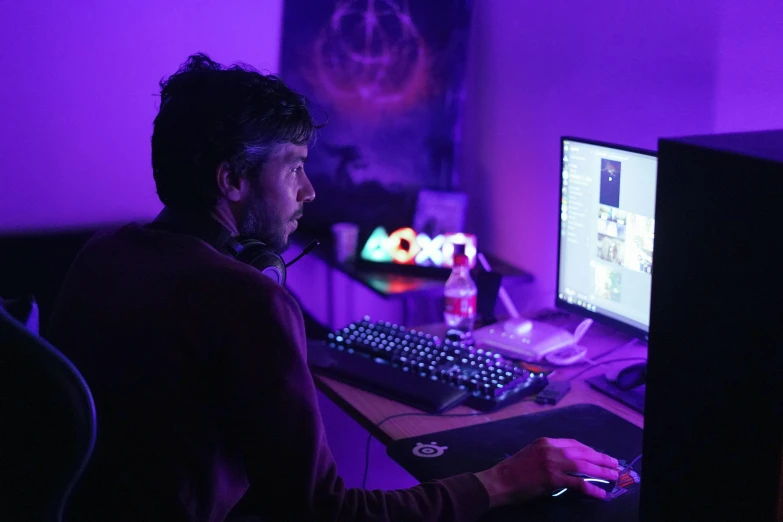 man at a desk with purple and black lighting