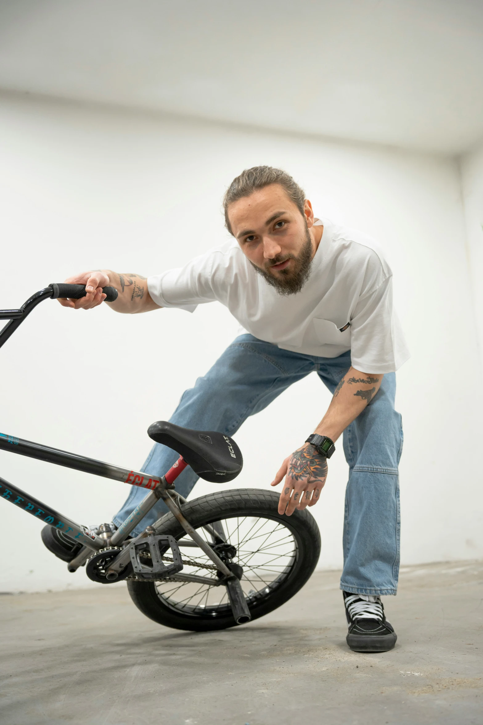 the man is fixing his bike in a white room