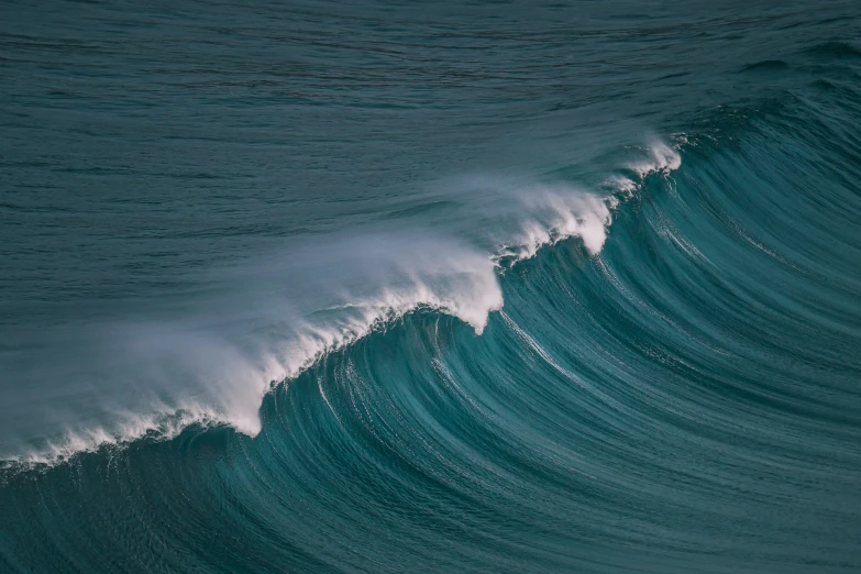 the ocean wave is making a long, white line to the water