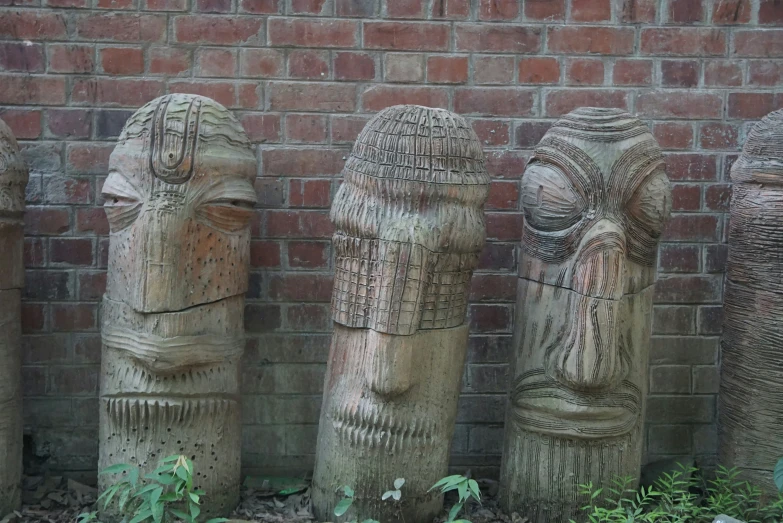 the three carvings are lined up against the brick wall