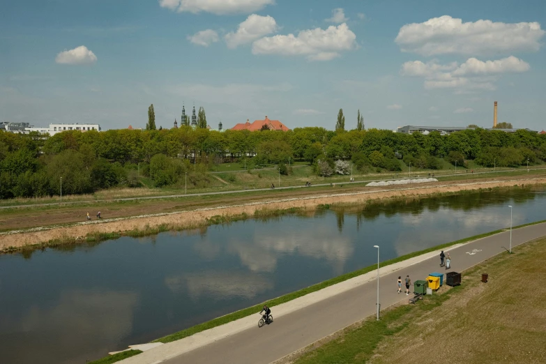 a river with people walking along it surrounded by trees