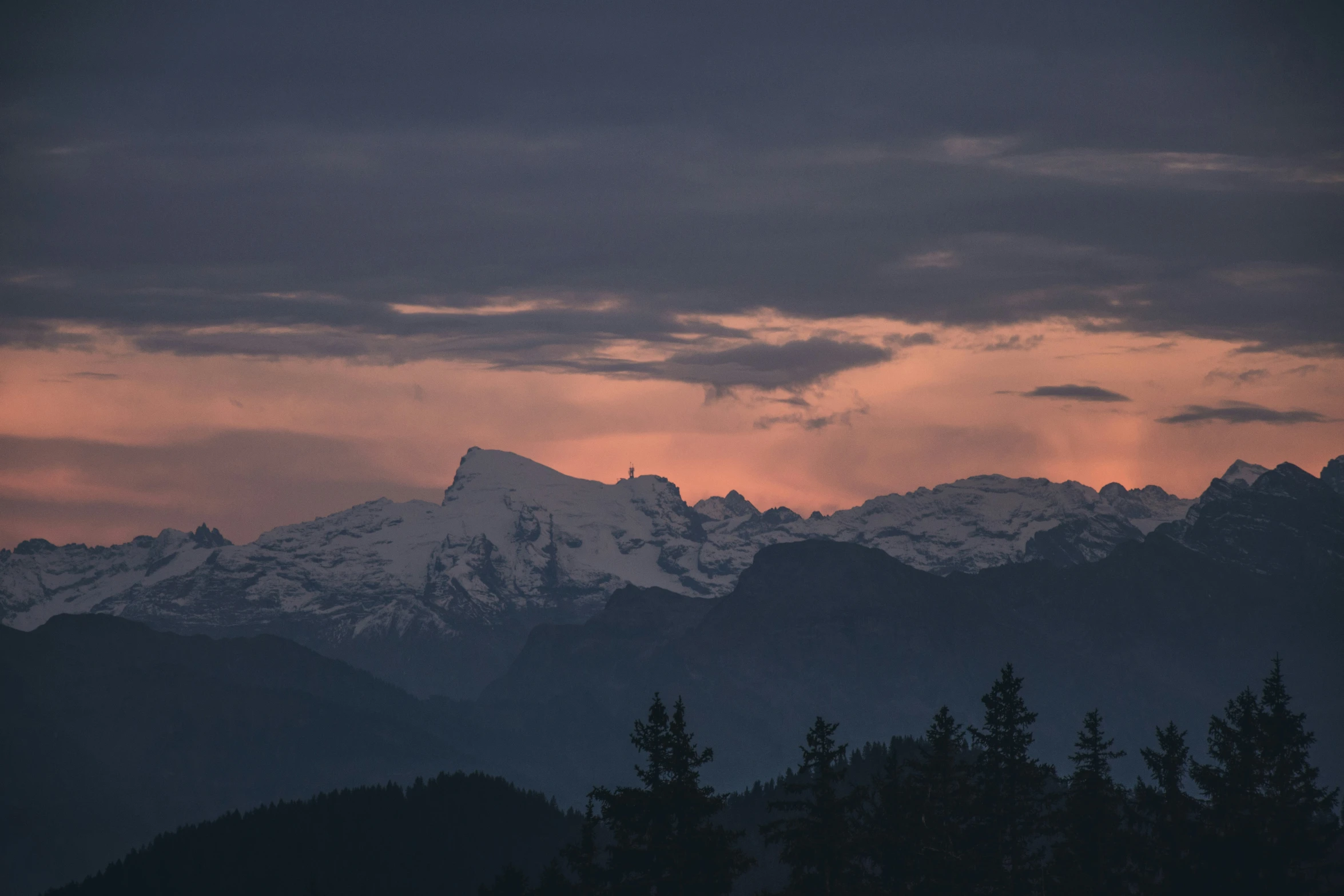 the mountains glow as the sun sets behind them