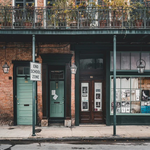 a building that has windows and doors and a street with trees on the balconys