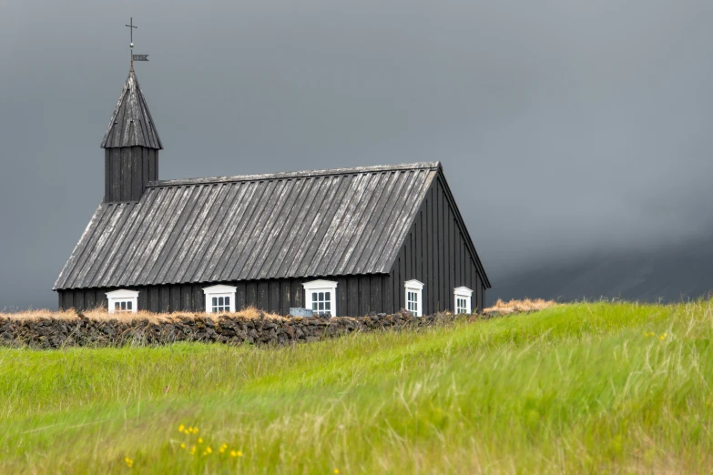 a building with two windows sits in a field