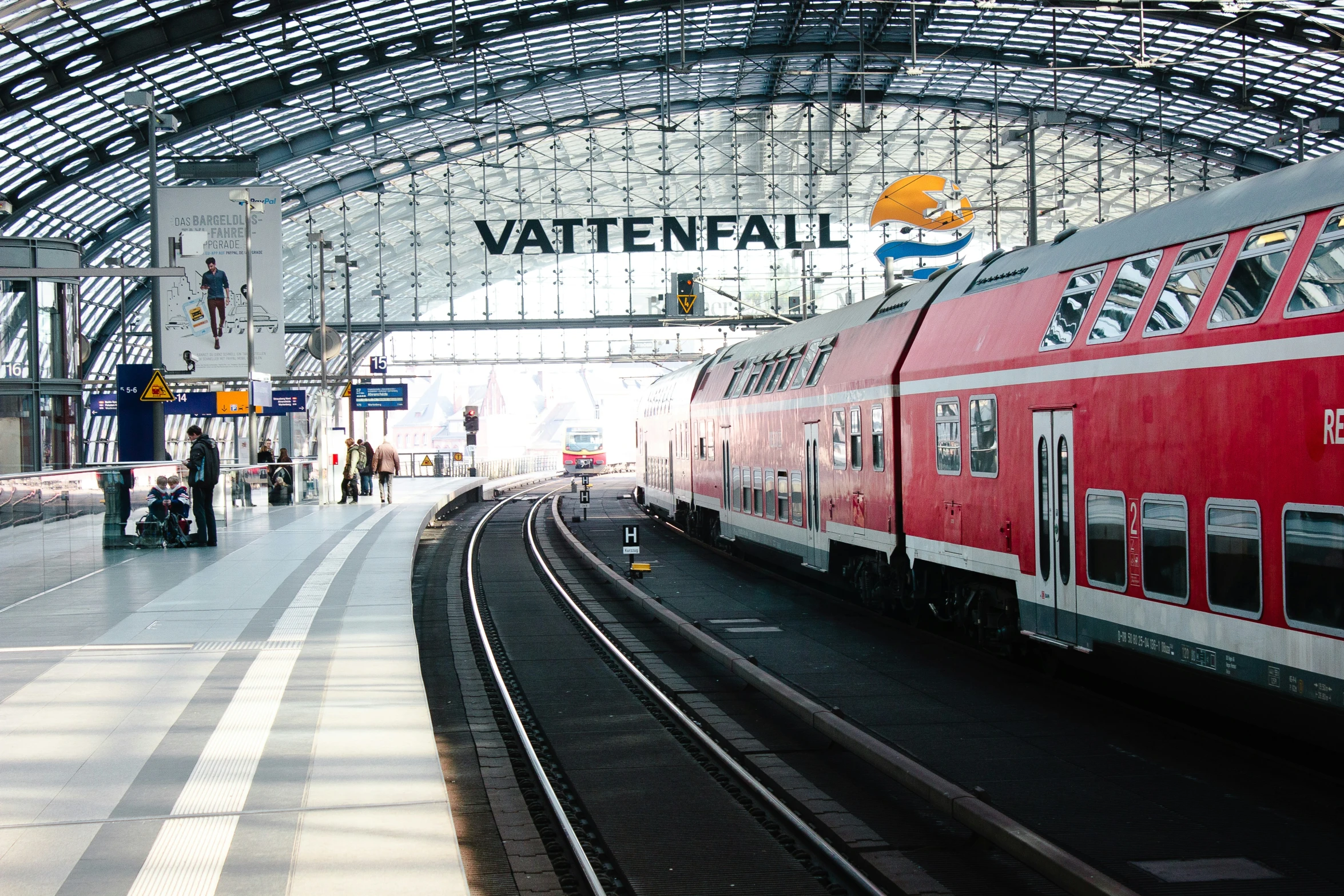 a train station with people standing on the platform