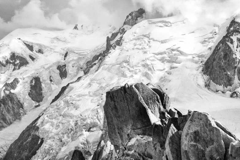 the mountains are covered in snow and clouds