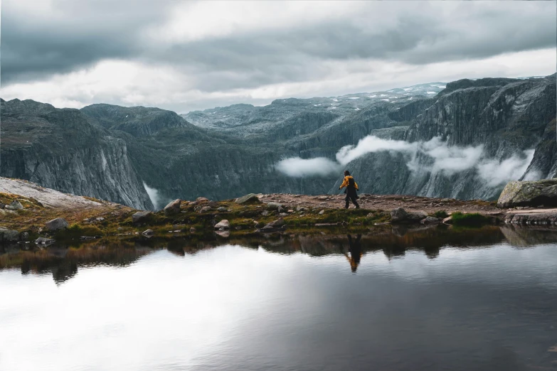 two people standing on the shore of a mountain lake