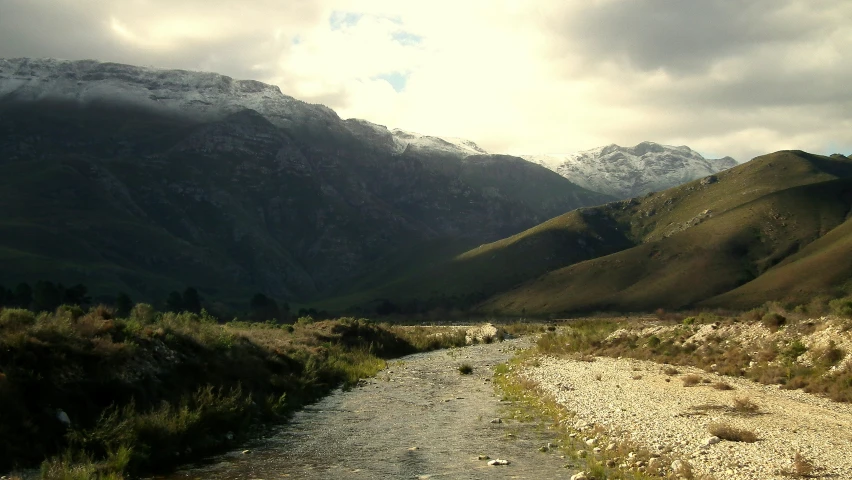 mountains and water near the side of the road