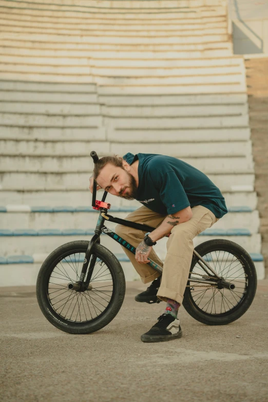 a man leans down on his bike while looking down at it