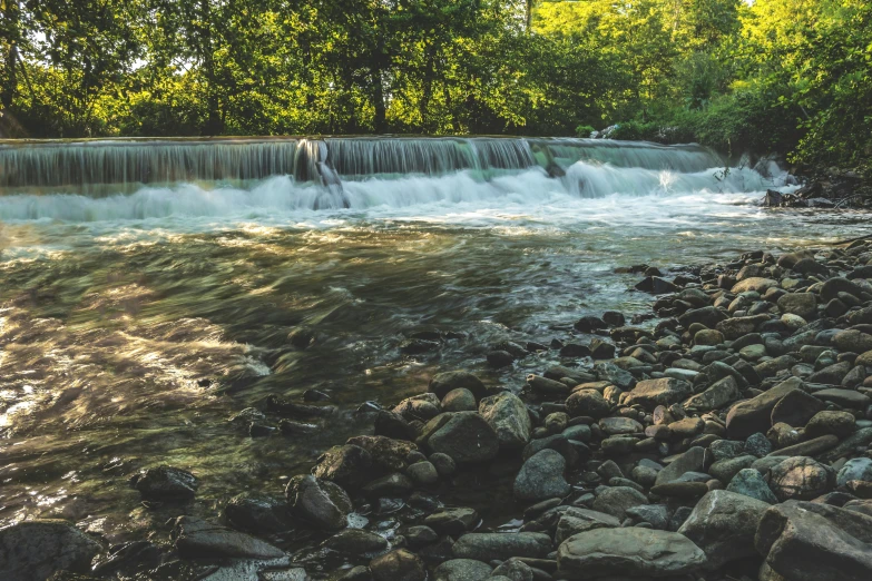 a waterfall on a sunny day with rocks