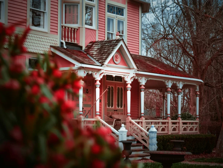a beautiful victorian house with pink sidings and white trim