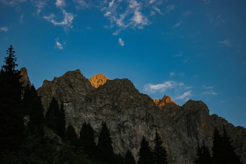 the sun sets on the top of a mountain