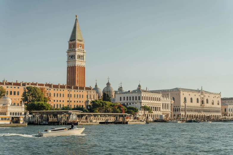 a boat in the water by a large clock tower