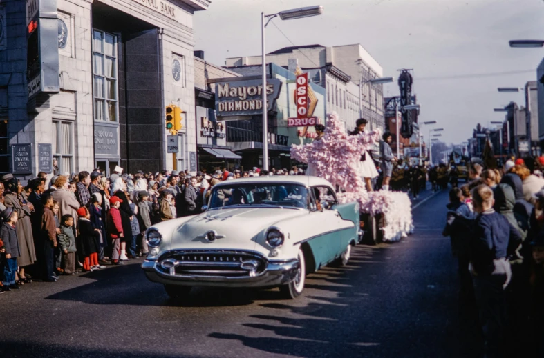 there are many people standing along side of the street watching a parade