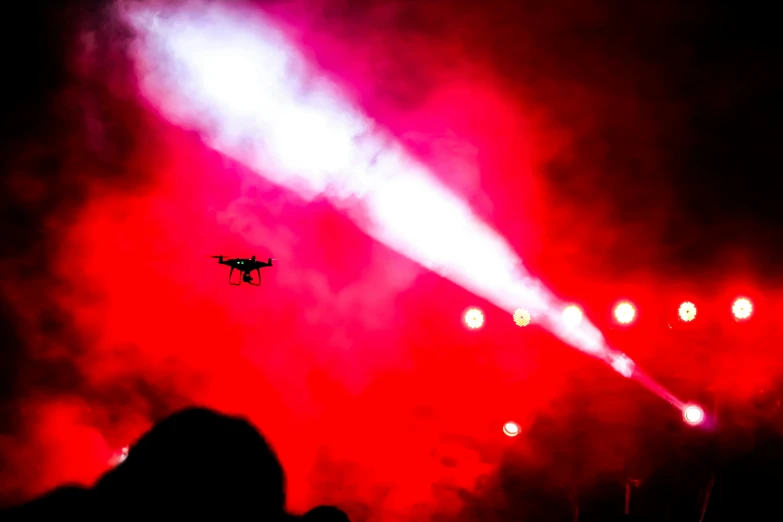 a plane flying over a concert with people watching