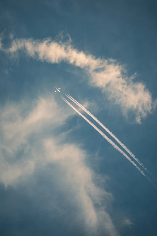 an airplane is flying in the sky with contrails