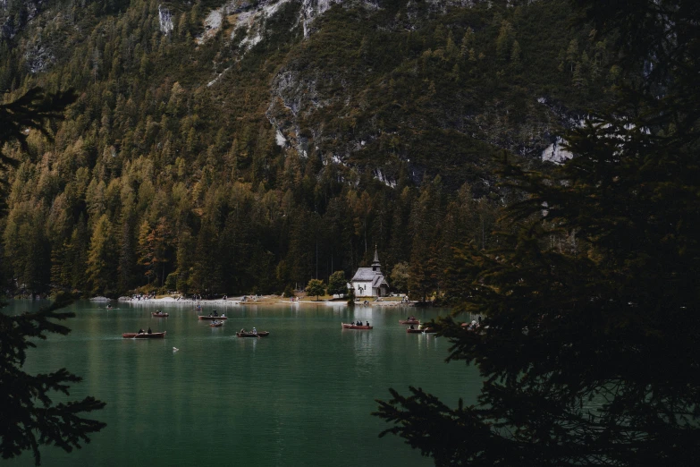 a green lake with many boats on it