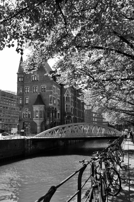 people on a dock in the city with a boat passing