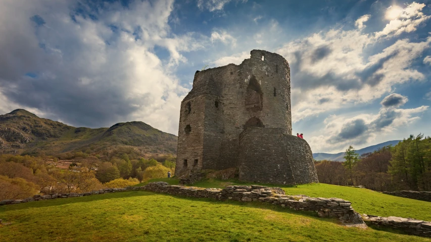 a view of a stone castle building with grassy ground below it