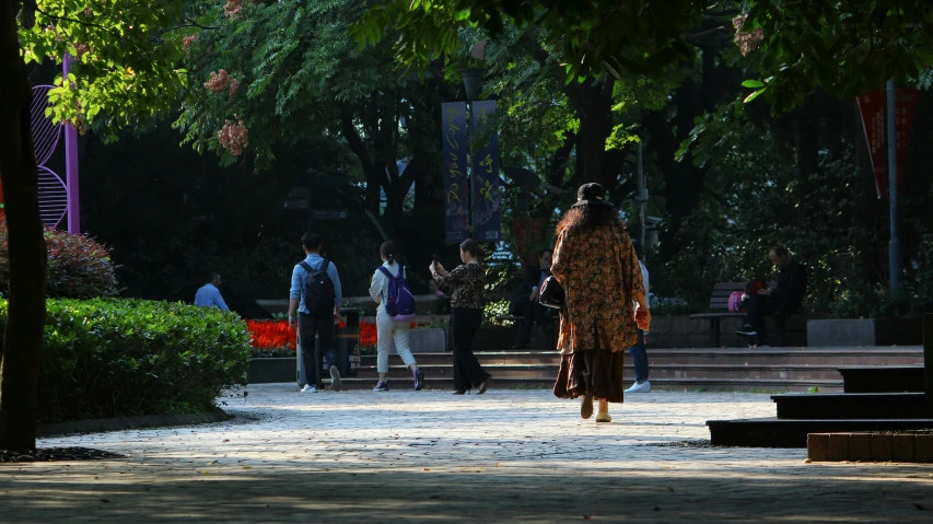 a woman is walking through the middle of a park