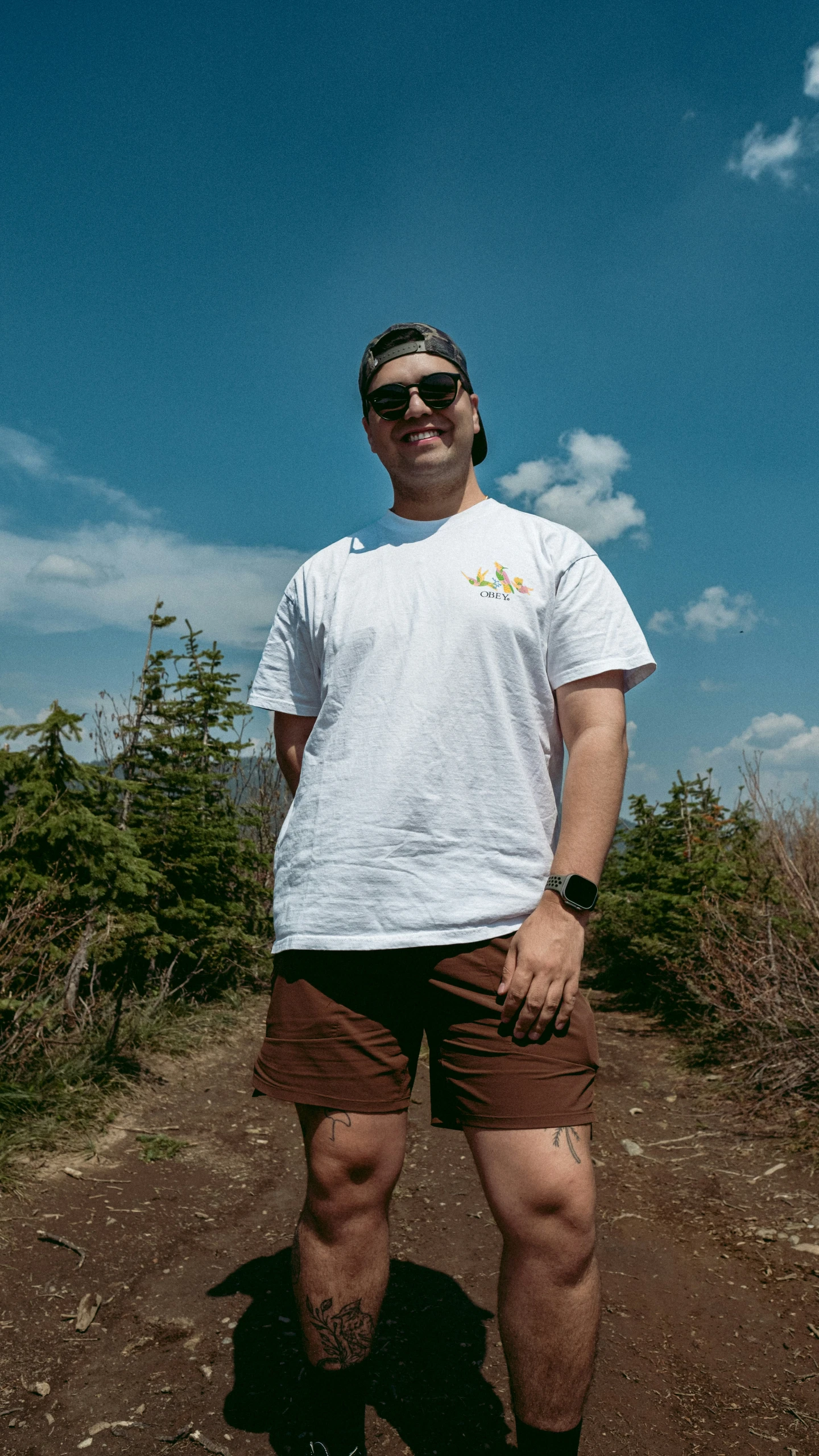 a man standing in front of some dirt and bushes