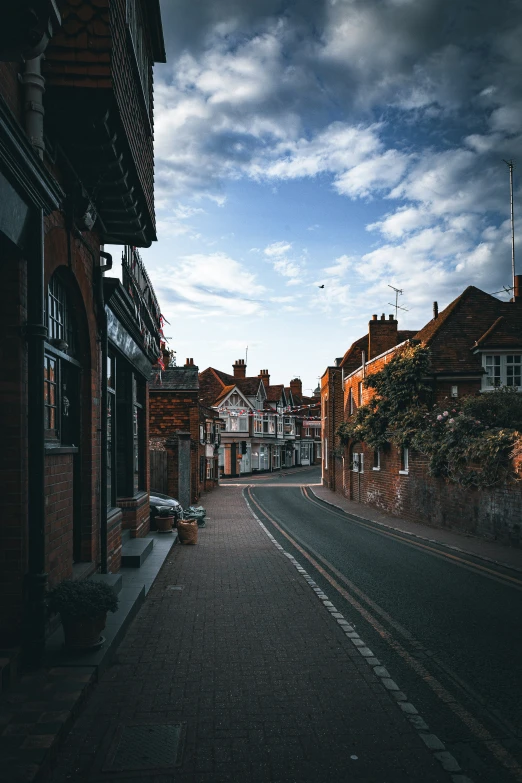 an empty dark street lined with brick buildings