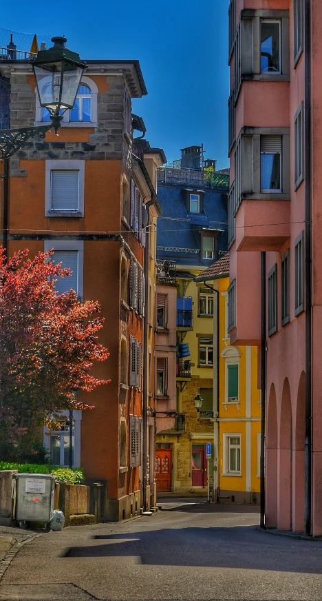 an old city street with parked cars on the side