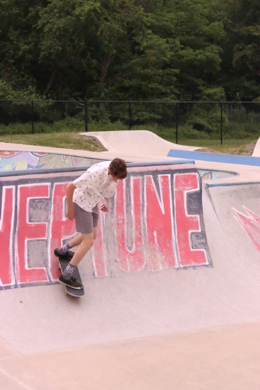 a skateboarder riding at the edge of an old - school ramp