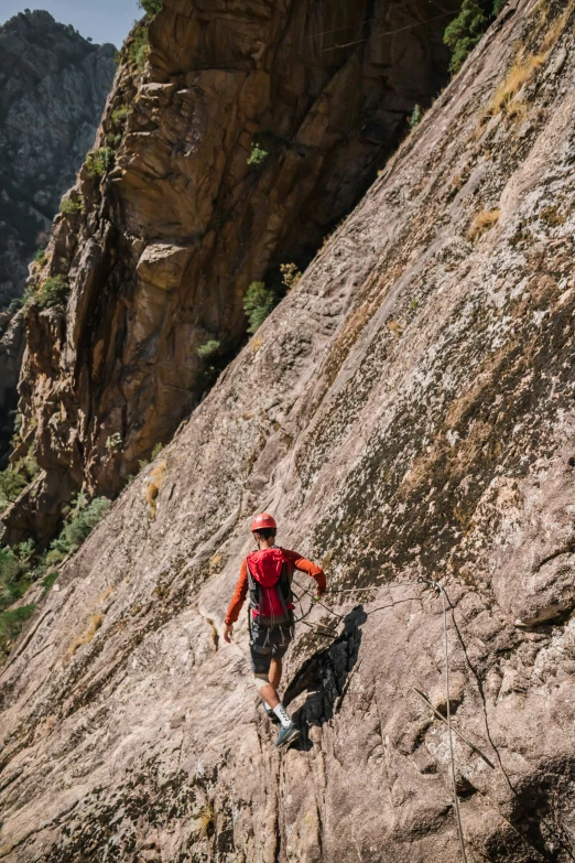 a man hiking up the side of a rocky mountain