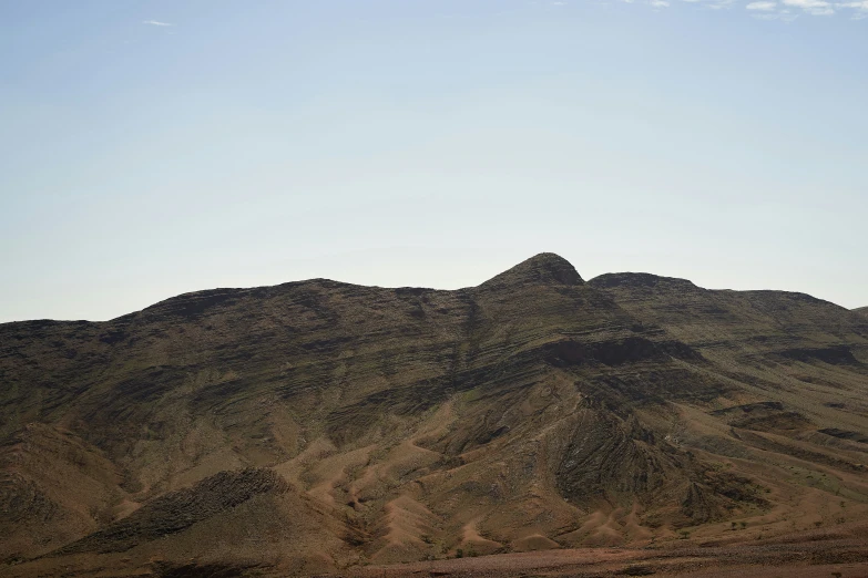 a very large rocky mountain with a boat sitting on the edge of it