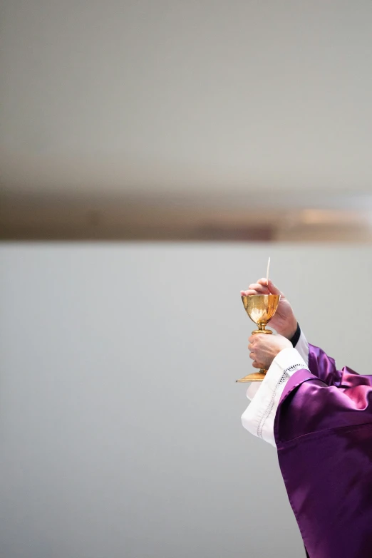 man in a priest's uniform holding an item with a torch