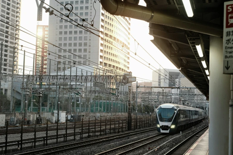 a train traveling down train tracks near tall buildings