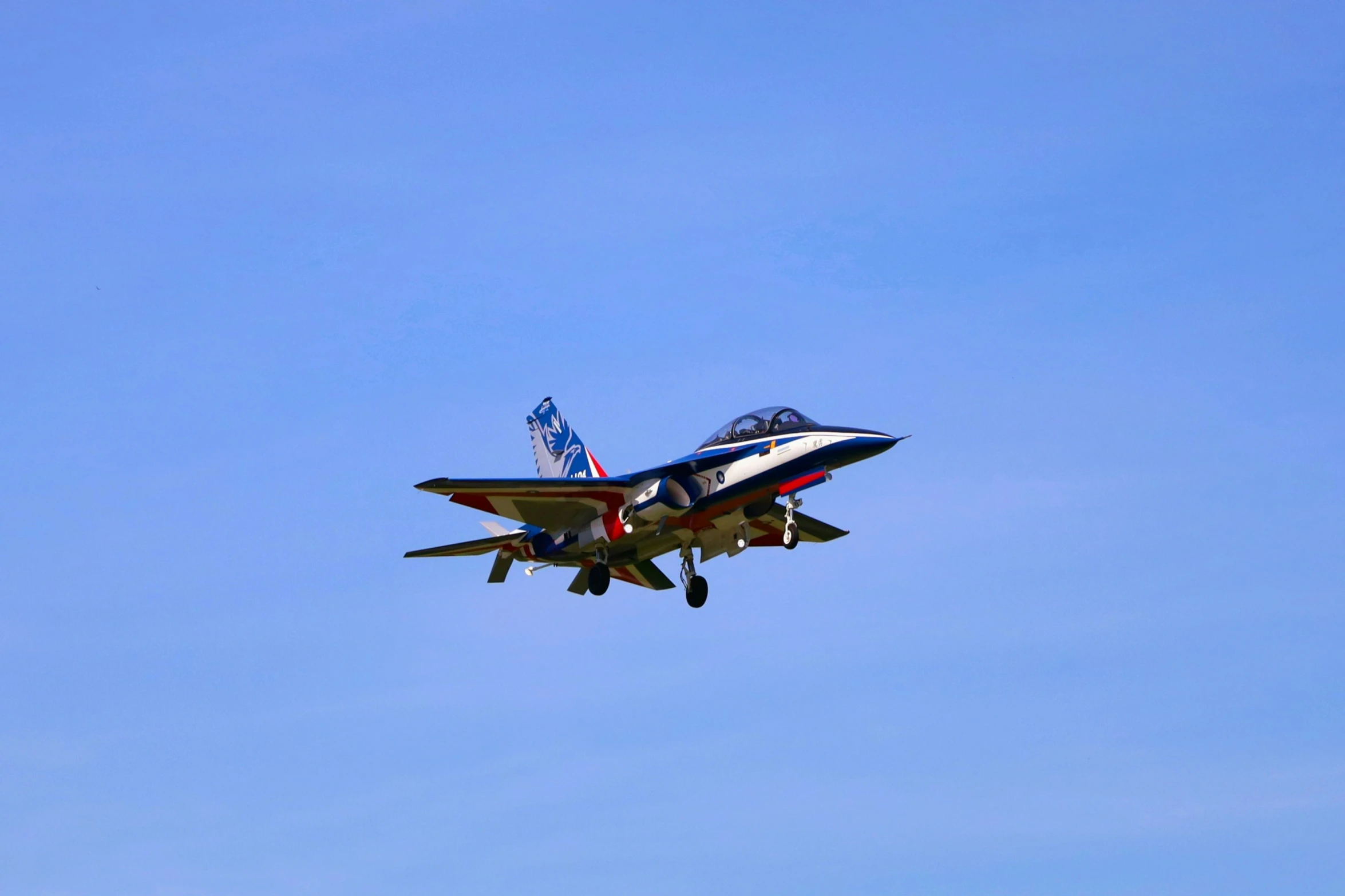 a fighter jet flying through the air with american flags on it's side