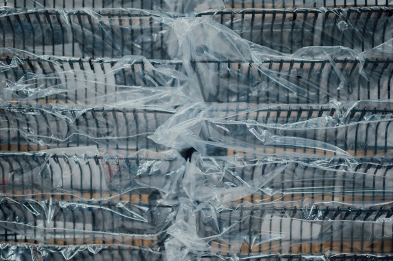 a cage full of empty silver baskets that have plastic covers over them