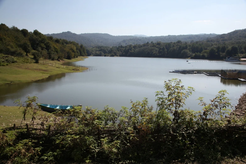 boats are docked at a lake surrounded by brush