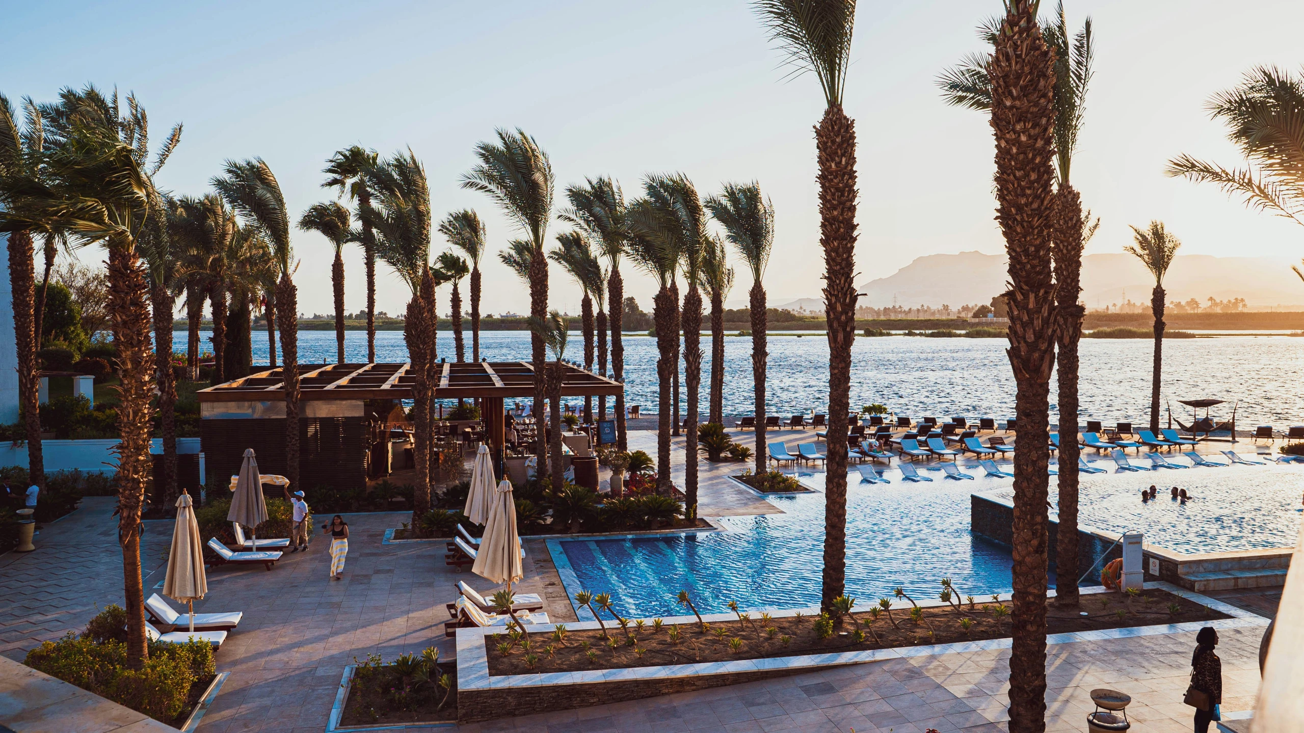 the pool at an empty beach resort is surrounded by palm trees