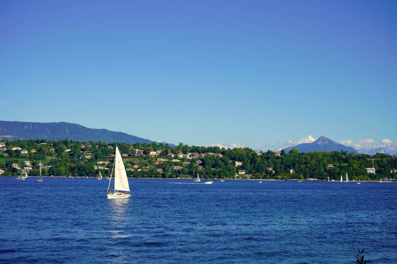 a small sail boat out in the water on a clear day