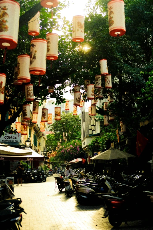 several tea light holders hang over a street side