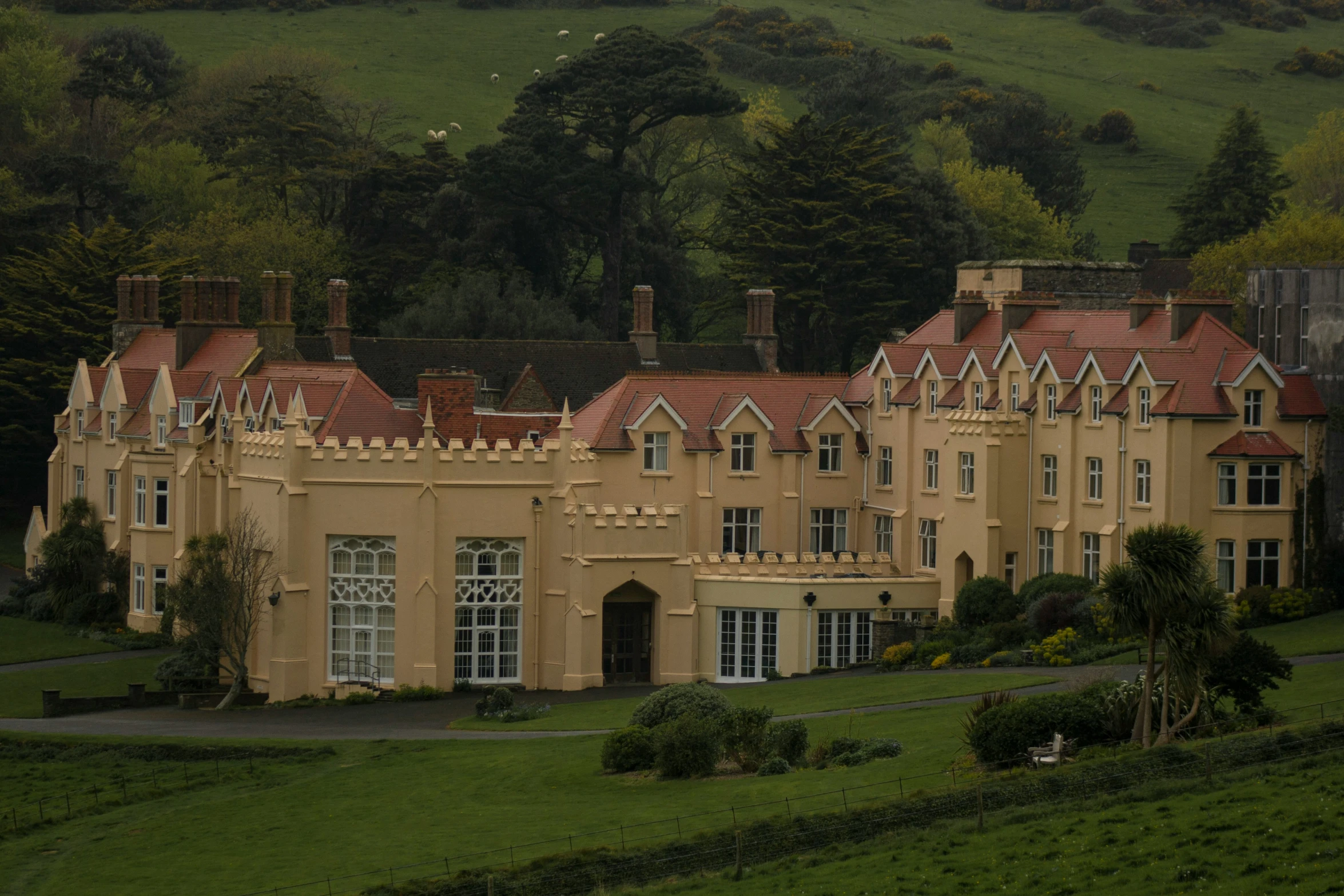 an ornate house with red roof and brown trim on the front