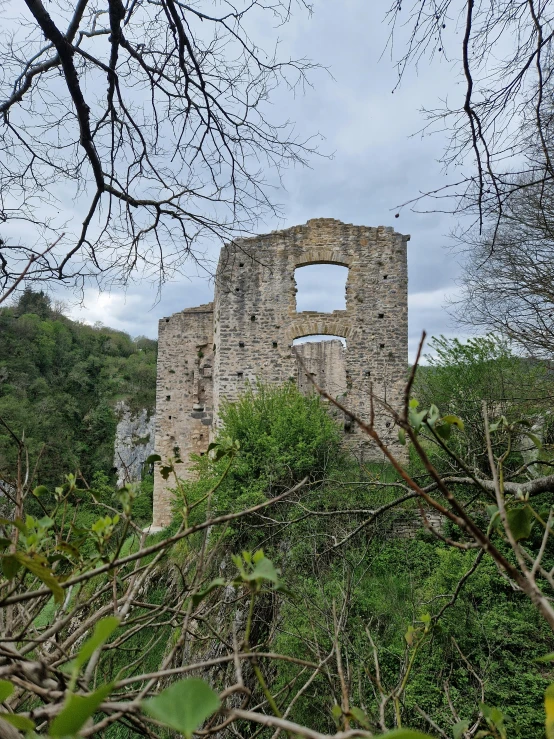 an old tower in the trees near a path