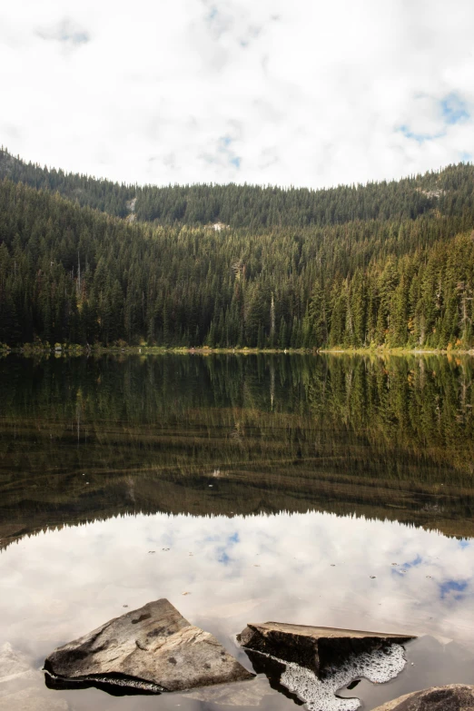 a mountain range reflects on the lake in front of it